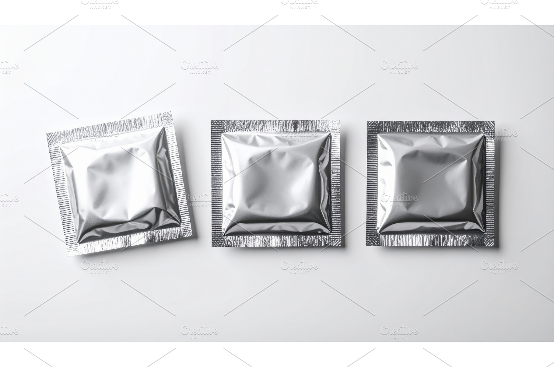 Three sealed silver condom packages, a Health & Medical Photo by Igor Tichonow