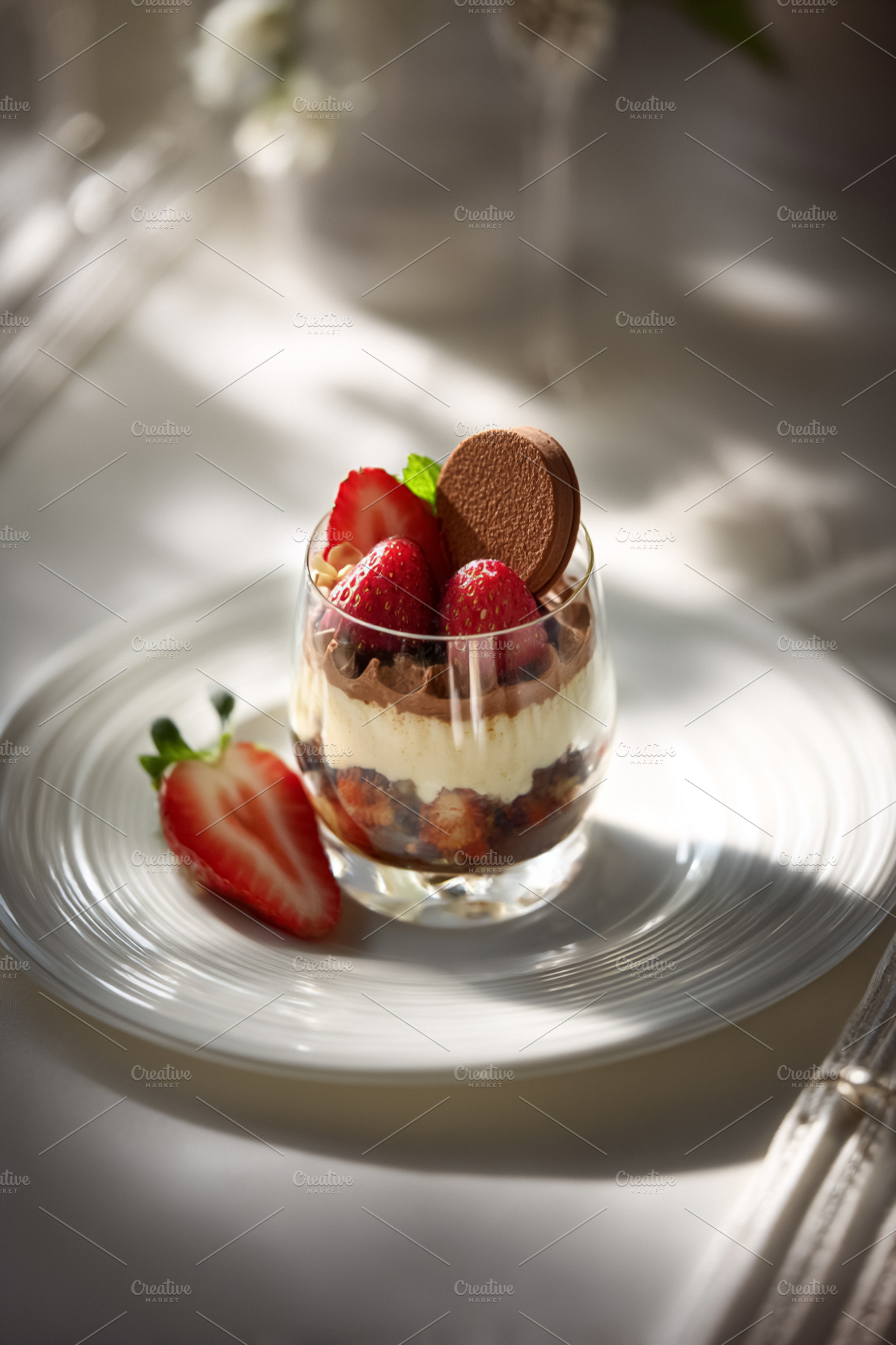 Glass of gourmet strawberry dessert presenting layers of mousse,, a Photo by Studio ANNA