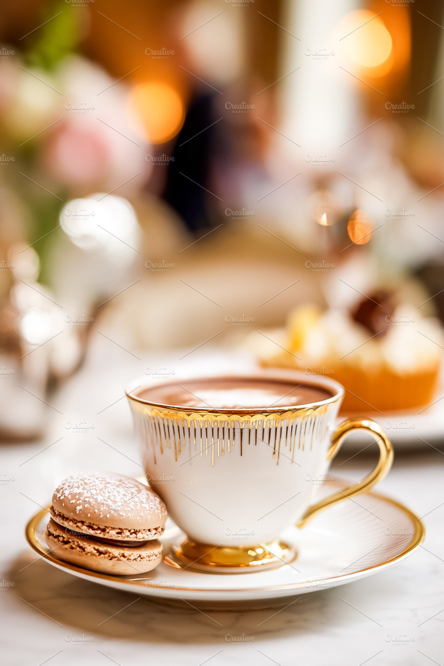 Hot chocolate and macaron served in an elegant porcelain cup wit, a Photo by Studio ANNA