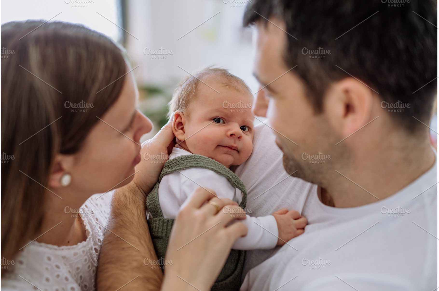 Happy parents cuddling with their, a Person Photo by HalfPoint