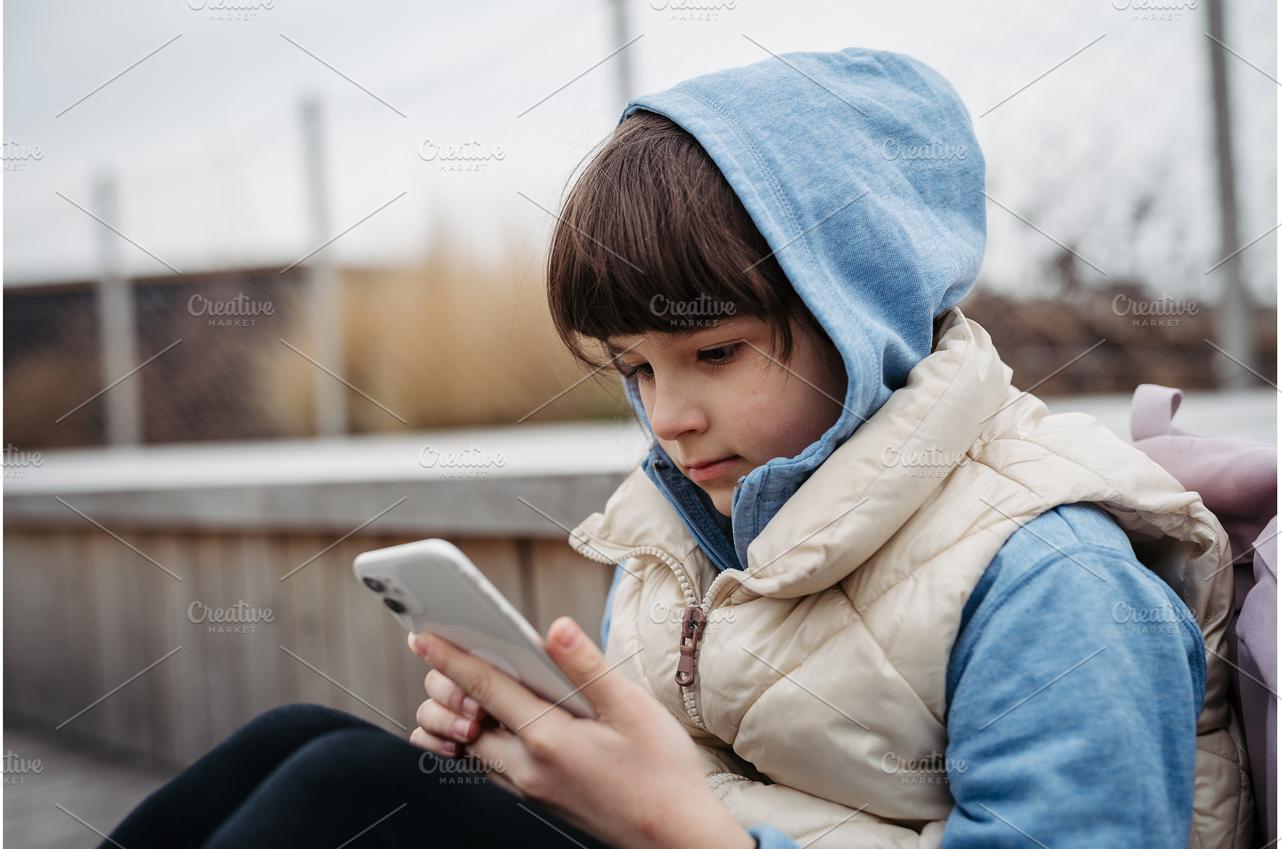 Girl sitting in front of school, a School & Education Photo by HalfPoint