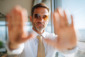 Confident businessman gestures for attention in modern office setting with city, a Person Photo by AlyaAnd