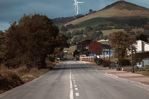 Road to hill with wind turbines, an Industrial Photo by SkyNext