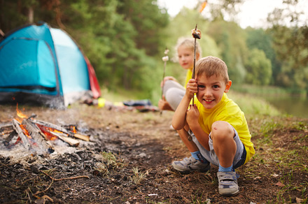 Happy children hiking in the forest containing camping, tent, and family