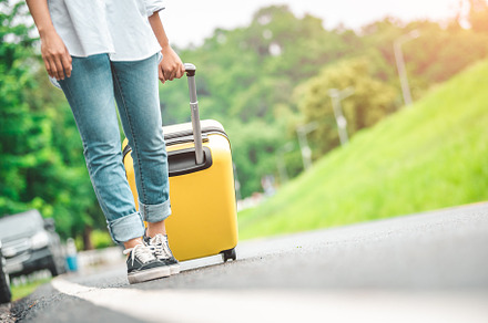 Closeup lower body of woman handling yellow trolly luggage along, a Transportation Photo by Ministocker
