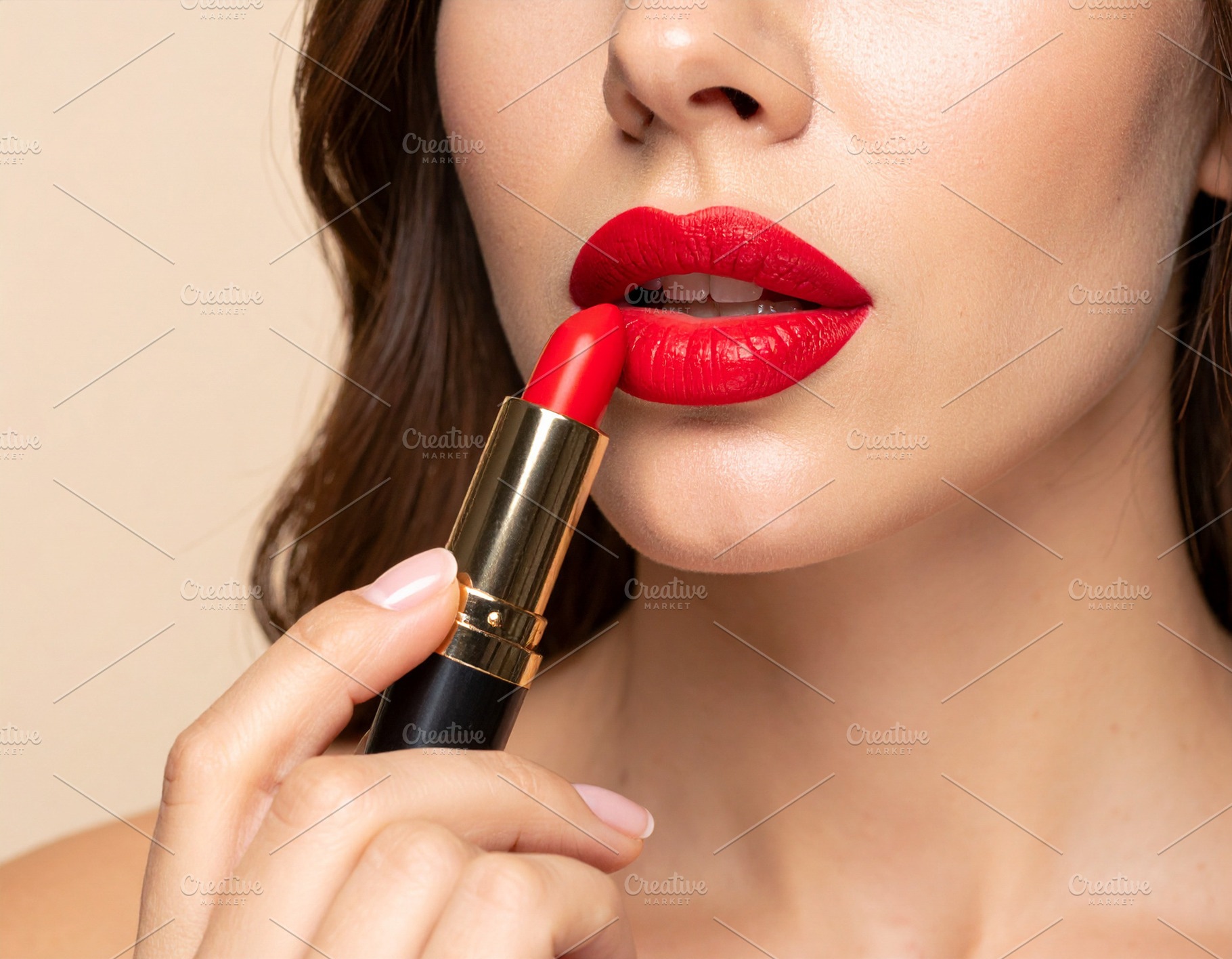 Woman applying bright red lipstick to her lips, a Health & Medical Photo by DanFLCreativo