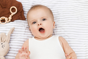 Beautiful happy baby lying on blanket with toys and teether in s, a Person Photo by Sonjachni