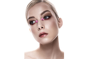 A womans face closeup with pink