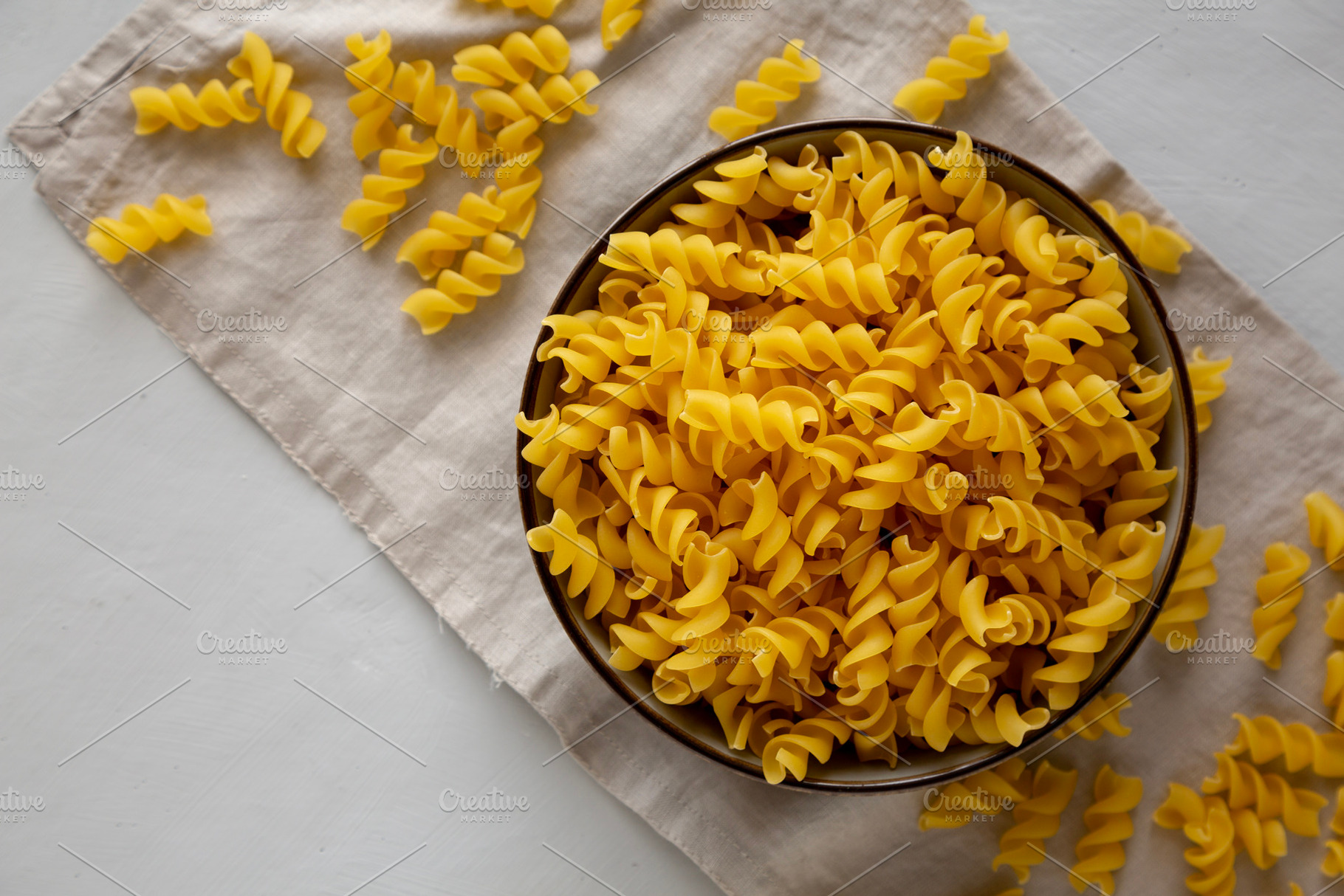Raw Dry Organic Fusillini Pasta in a Bowl, top view., a Food & Drink Photo by LiudmylaChuhunova