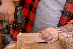 Joiner occupation drilling wood corner joint plank, a Person Photo by Photo Drive Studio