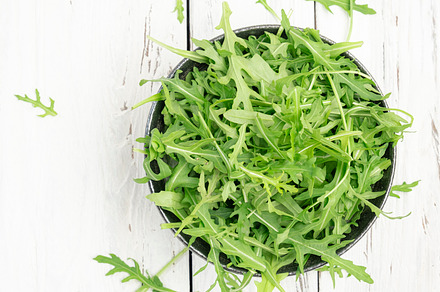 Fresh green arugula in rustic ceramic bowl on white kitchen tabl, a Food & Drink Photo by 5PH