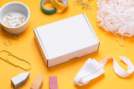 white cardboard box on color office desk, a Background Photo by MDBildes