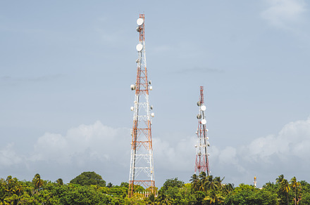Two signal towers on an island shore, a Nature Photo by SkyNext