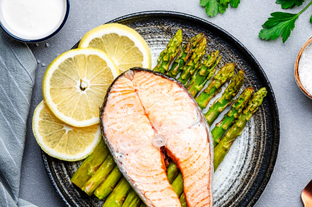 Steamed salmon with baked asparagus and lemon on ceramic plate., a Food & Drink Photo by 5PH