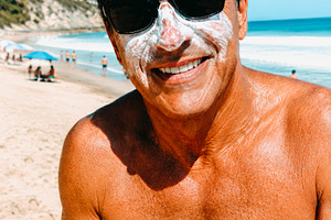 a man wears sunscreen on a beach, generative AI, a Photo by Nito