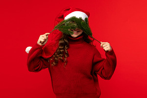 Girl in Santa hat holding fir branch, a Holiday Photo by Elena Vagengeim