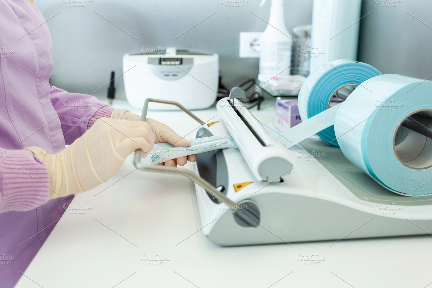 Nurse packing medical instruments using a vacuum packing machine, a Health & Medical Photo by Antonio Gravante Market