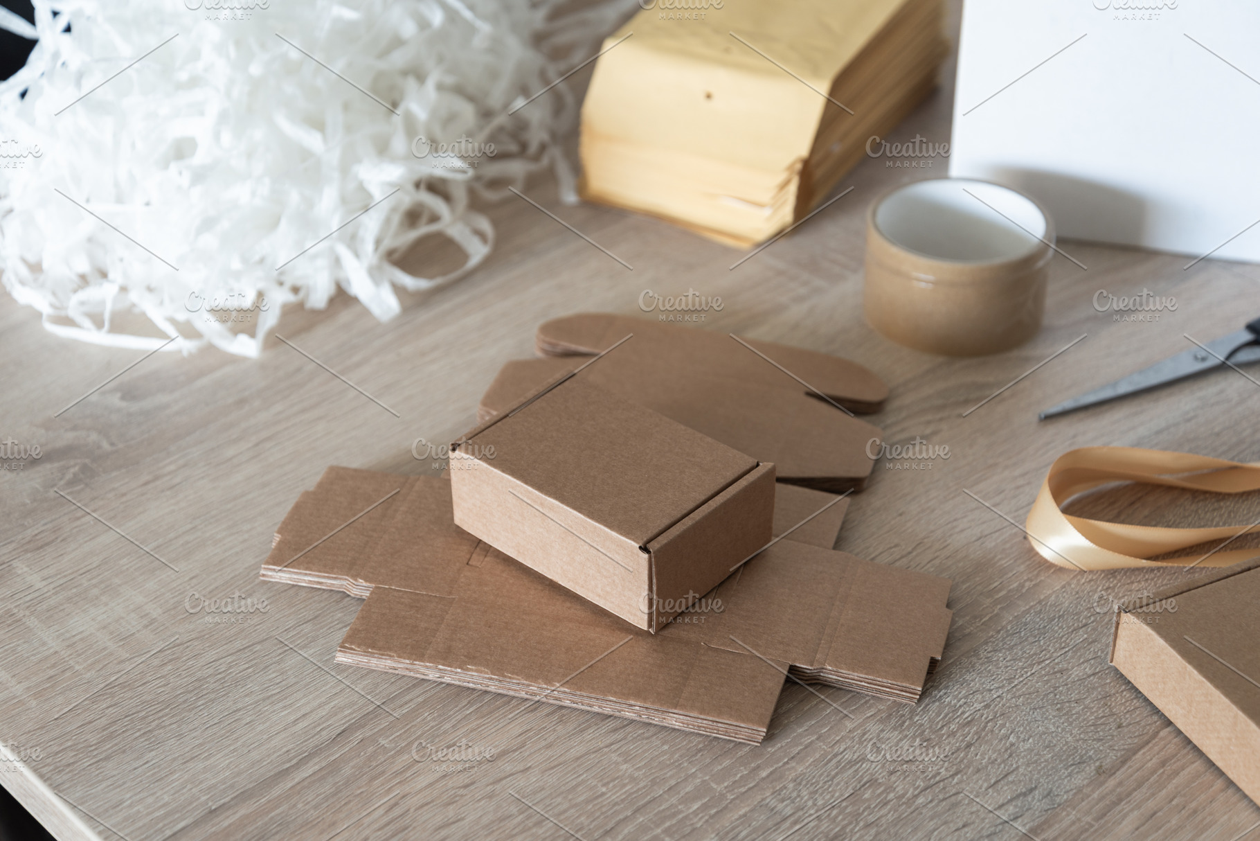 Small cardboard box with packing filler on work table, an Industrial Photo by MDBildes