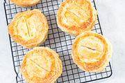 Small beef pot pies on cooling rack, top view, square, a Food & Drink Photo by iuliia_n (Thumbnail 2 of 2)