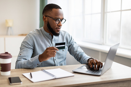 African American Businessman Using Credit Card And Laptop In Office, a Background Photo by Prostock-Studio