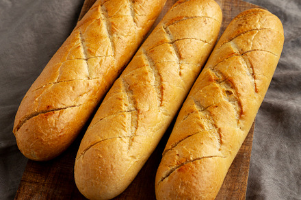 Homemade French Baguette with Garlic Filling on a wooden board,, a Food & Drink Photo by LiudmylaChuhunova