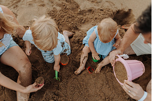 Two toddler children playing on sand, a Person Photo by HalfPoint