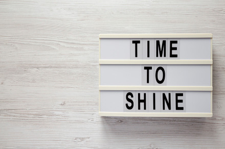 'Time to shine' on a lightbox on a white wooden surface, top vie, a Business Photo by LiudmylaChuhunova