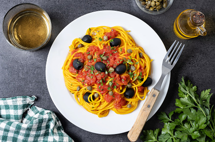 Italian Pasta puttanesca with tomato sauce, capers, and black olives on black s, a Food & Drink Photo by etorres69