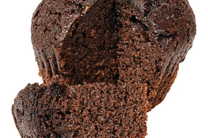A partially cut dark chocolate muffin or cupcake, revealing its, a Food & Drink Photo by ndanko