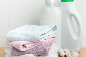 Stack of soft clean towels with laundry detergents, an Industrial Photo by Olena Rudo
