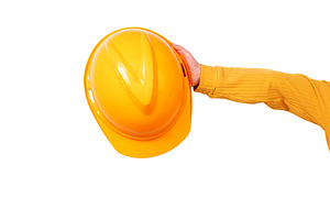 Close-up of a hand holding a yellow construction safety helmet a, an Industrial Photo by Ales Munt