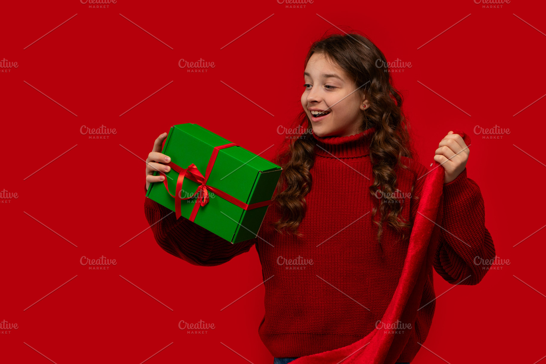 Excited girl holds Christmas gift an, a Holiday Photo by Elena Vagengeim