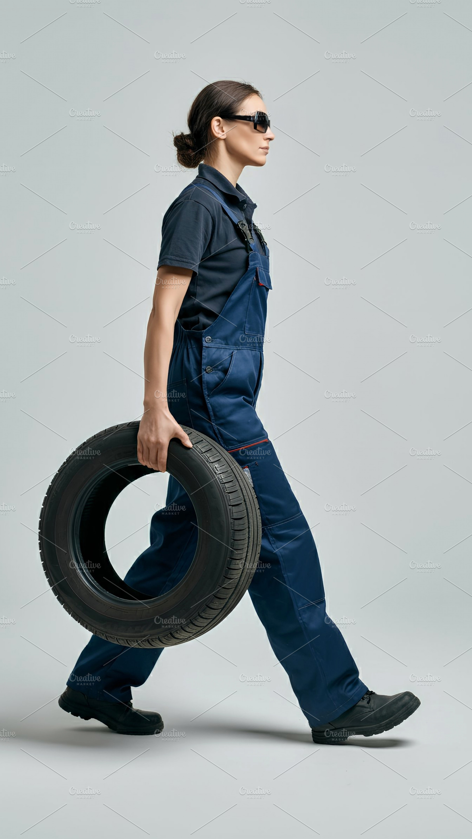 Confident Mechanic Woman Carrying Ti, a Transportation Photo by Stock Shape