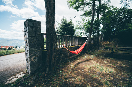 Red hammock between trees outdoors, a Sports & Recreation Photo by SkyNext