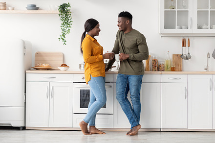 Young Black Married Couple Spending Time Together In Kitchen At Home, a Photo by Prostock-Studio