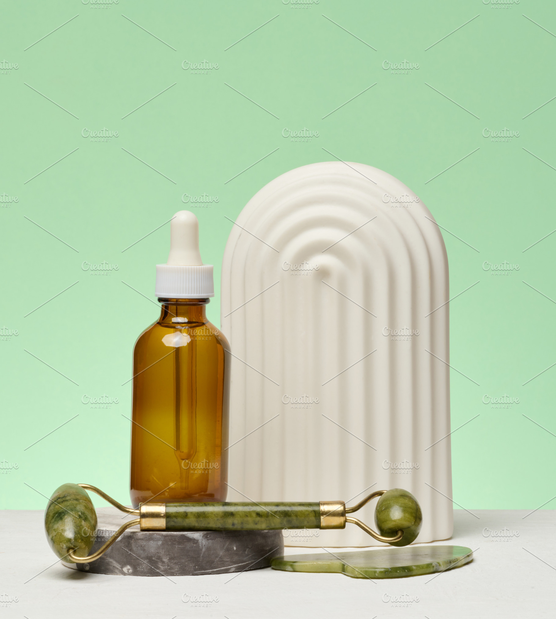 A bottle with a pipette, a jade facial massage roller and a deco, a Beauty & Fashion Photo by ndanko