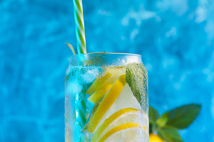 summer cold lemonade with lemon and mint, blue background.