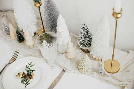 Modern Christmas table setting. Cedar branch with bell on plate,, a Holiday Photo by Sonjachni