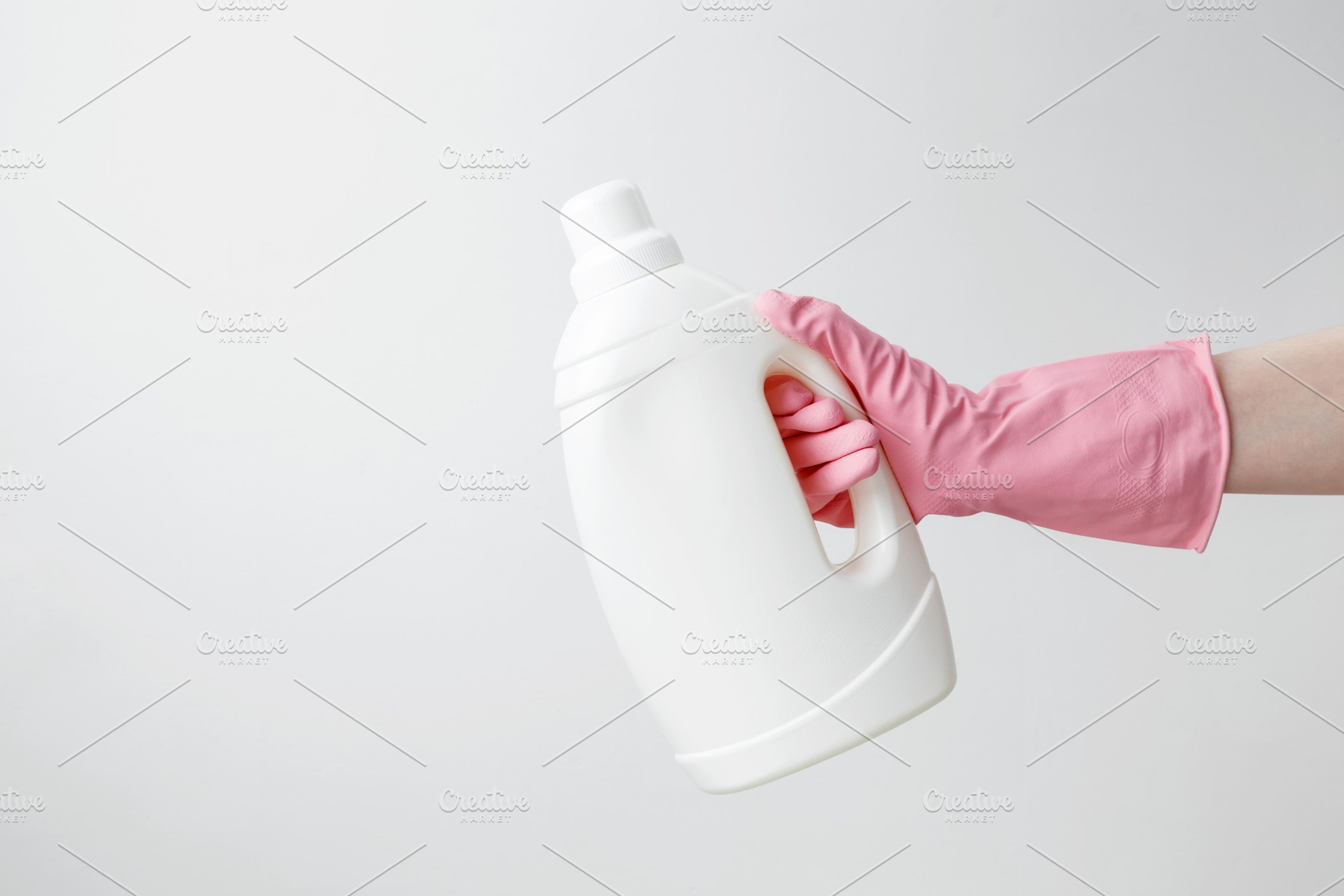Female hand in a pink rubber glove holding a white branding mockup of laundry g, a Photo by matucha