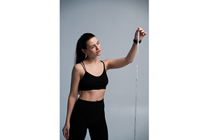 Woman standing, holding a measuring, a Sports & Recreation Photo by volodymyrshtun13795