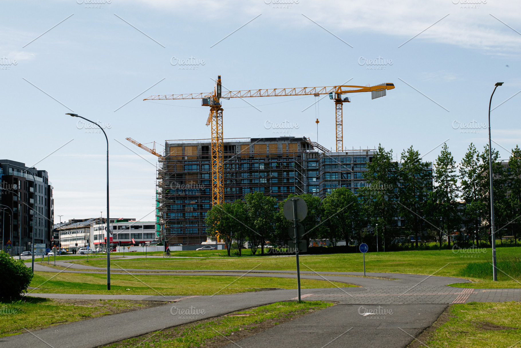 Construction site with cranes in Reykjavik, Iceland on a sunny day, a Photo by AS photostudio