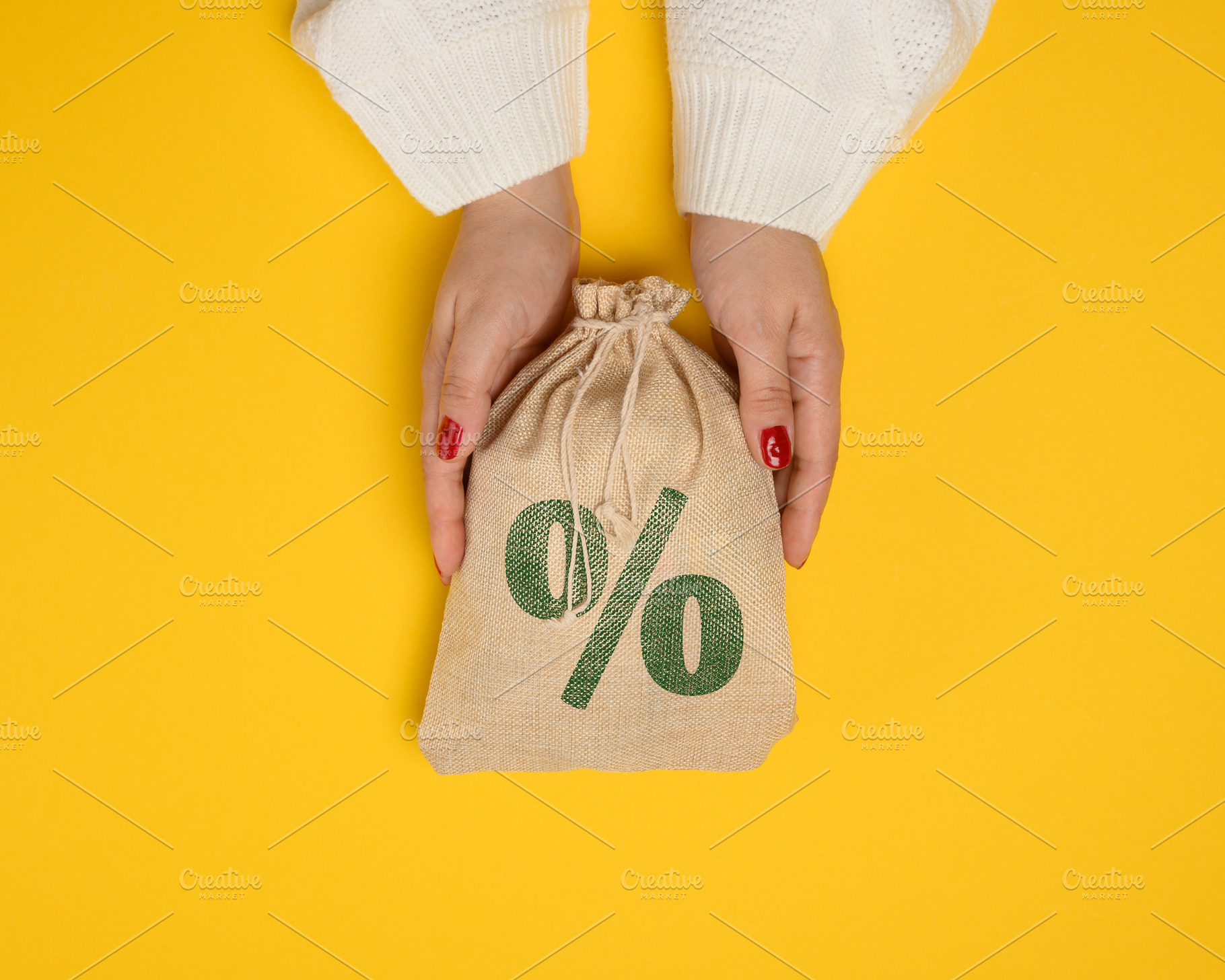 Female hands in a white knitted sweater holding a burlap bag wit, a Business Photo by ndanko