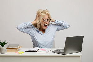 Pay raise. Overjoyed female office worker looking at laptop screen with excitem, a Photo by Prostock-Studio