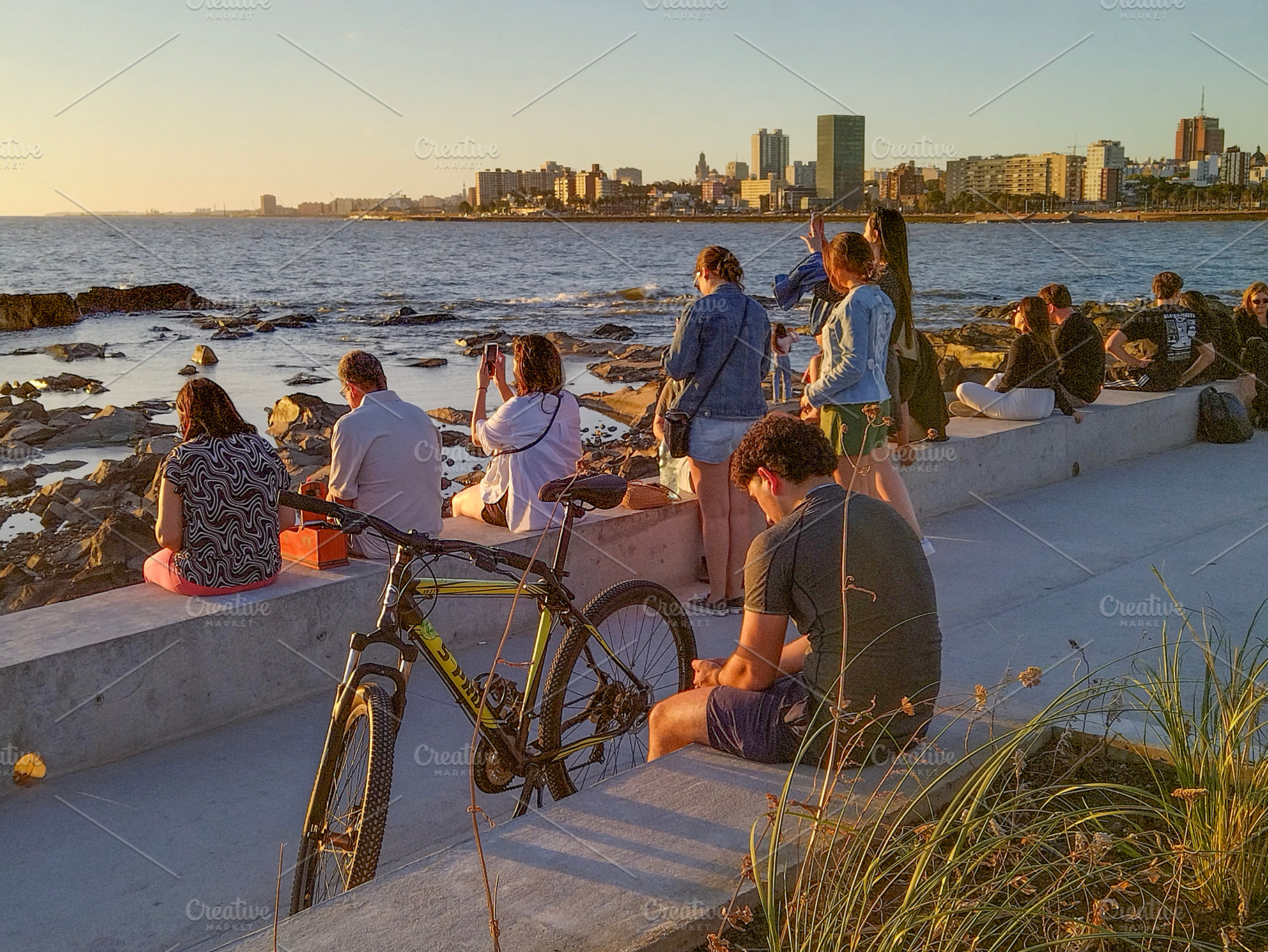 People enjoying golden hour by the waterfront promenade, a Person Photo by DanFLCreativo