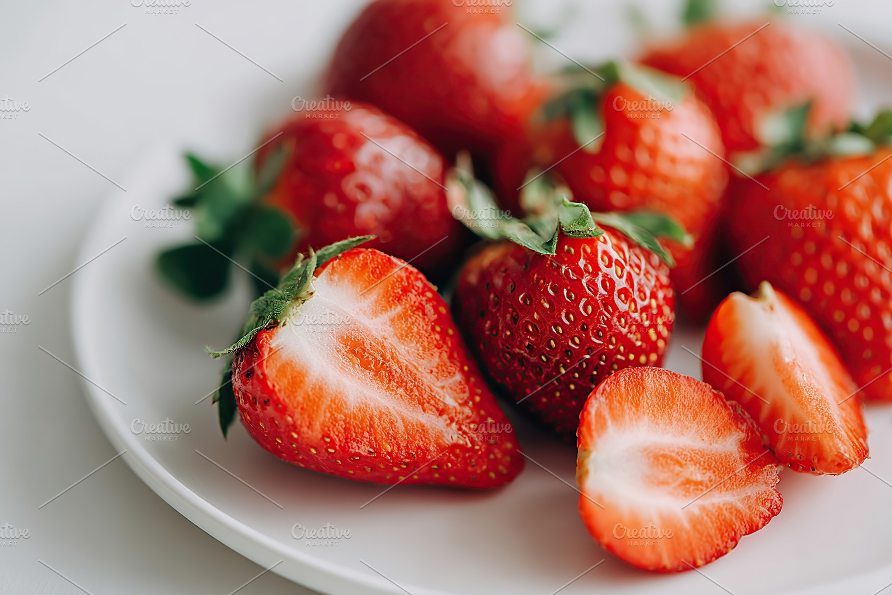 Fresh red strawberries on a white plate ready to be enjoyed or used in desserts, a Food & Drink Photo by AlyaAnd