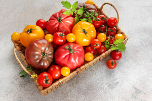 Heirloom tomatoes in a basket showing harvest variety, a Food & Drink Photo by Olena Rudo