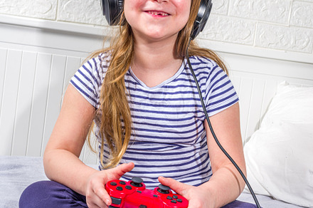 Llittle child kid girl playing video games, a Photo by Rimma