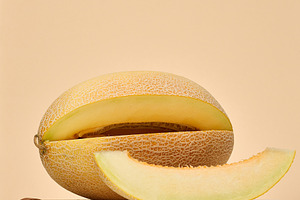Cantaloupe melon and a separate slice on a beige background, a Food & Drink Photo by ndanko