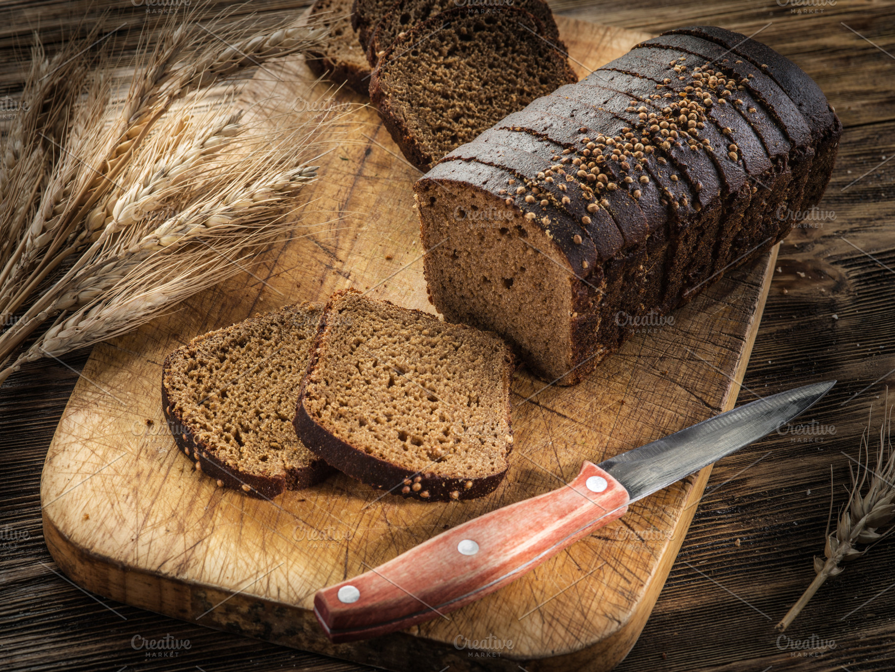 Sliced black bread on the wooden plank., a Food & Drink Photo by Volff