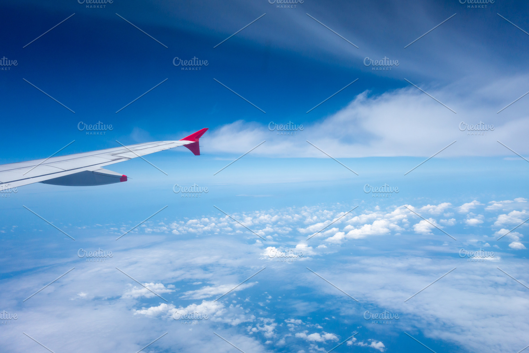 View from an airplane wing above the clouds, a Nature Photo by GoodGoods